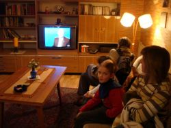 ouders en kinderen van 2008  kijken in een nagebouwde DDR-huiskamer naar DDR-tv